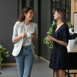 Zwei Frauen mit Kaffeetasse im Gespräch.