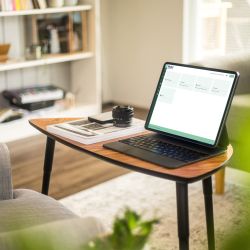 Geöffneter Laptop mit der Startseite des Online-Service-Portals auf einem Tisch im Wohnzimmer.