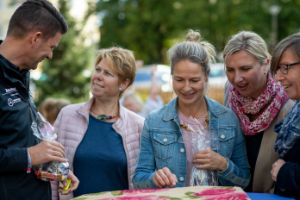 Gruppe von Ausbildern auf einer feierlichen Veranstaltung im Freien. Sie verteilen Geschenke.