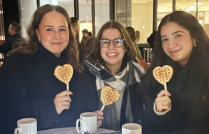 Auszubildende sitzen draußen am Tisch und unterhalten sich. 