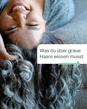 Gut gelaunte Frau mit grauen Haaren lacht in die Kamera über ihr. 