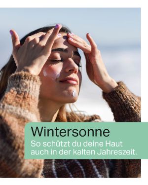 Wintersonne – So schützt du deine Haut auch in der kalten Jahreszeit. "Eine junge Frau cremt sich das Gesicht ein."