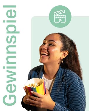 Gewinnspiel Schanzenkino: Junge Frau mit Popcorn-Tüte in der Hand lächelt. 