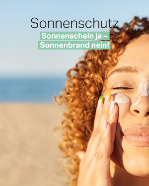 Frau cremt sich ihr Gesicht mit Sonnencreme ein. 