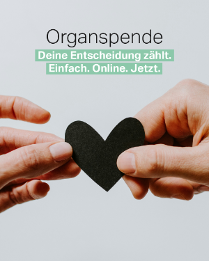 Zwei Hände halten ein Herz aus Papier fest. 
