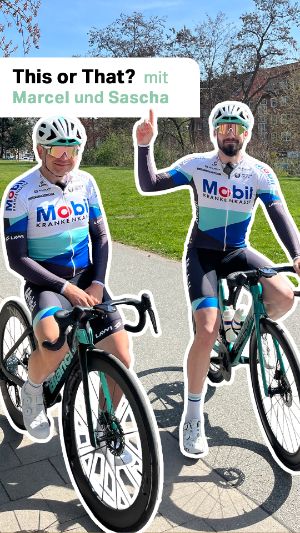 Cycling Team: This or That? mit Marcel und Sascha. Marcel und Sascha sitzen auf ihrem Fahrrad und zeigen nach oben. 