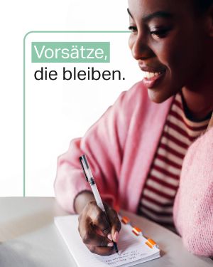 Mental Gesund: Vorsätze, die bleiben. Eine Schwarze junge Frau schreibt in einem Notizblock.