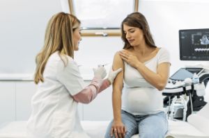 Eine Schwangere bekommt eine Impfung von einer Ärztin.