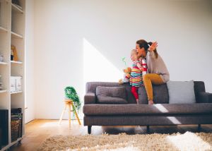 Mam_mit_Kind_spielen_Flugzeug_auf_Sofa_GettyImages-542946232