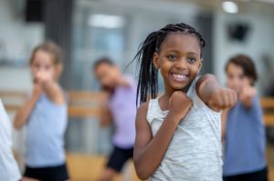 Ein Kind trainiert Boxtechniken mit einem Trainer und stärkt Körpergefühl sowie Selbstvertrauen im sicheren Übungsumfeld.