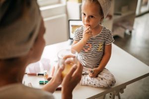 Eine Mutter gibt ihrer kleinen Tochter Medikamente.