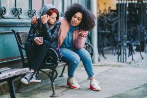 Zwei junge Frauen in einer Umarmung.