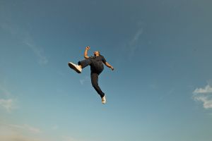 Junge Frau wagt Neuanfang und springt in die Luft.