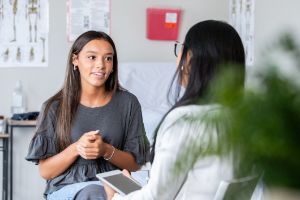 Teenagerin beschreibt Ärztin ihre Symptome.