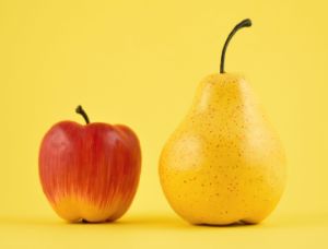 Ein roter Apfel und eine gelbe Birne stehen vor einem gelben Hintergrund.