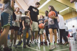 Dirk Nowitzki ist umringt von vielen Kindern mit Basketbällen.