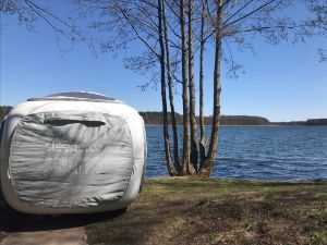Ein Sleeperoo Würfelzelt steht an einem See