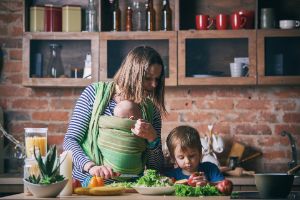 Kleinkind hilft junger Frau beim Kochen