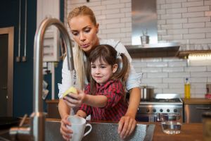 Kind hilft Mutter im Haushalt beim Abwaschen