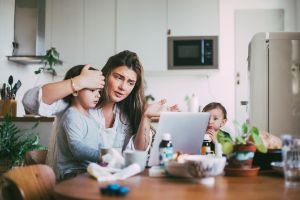 Mutter sitzt mit ihrem kranken Kind vorm PC.