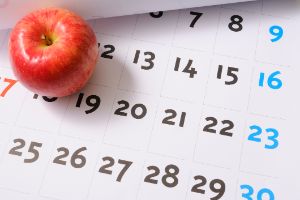 Ein Apfel liegt auf einem Kalenderblatt.