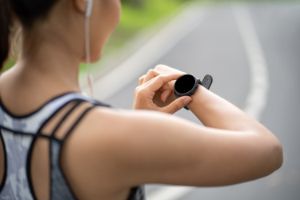 Zwei Frauen in Sportklamotten lachen und nehmen sich in den Arm.