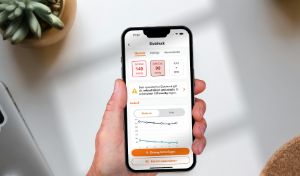 Eine Hand hält ein Handy, auf dem die manoa App geöffnet ist.