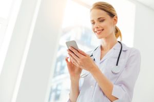 rztin mit Smartphone und Stetoskop