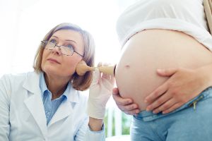 Babybauch wird bei einer Untersuchung abgehoert
