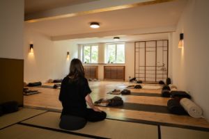 Ein Yogakursraum mit einer Frau auf einer Matte.