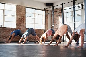 Mehrere Personen praktizieren Yoga in einem Loft-Studio.