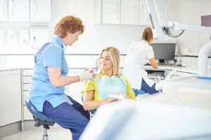 Eine Zahnärztin berät eine Patientin im Behandlungsraum.