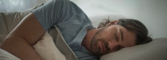 Ein Mann liegt im Bett und schläft.
