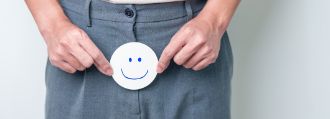 Man sieht einen Mann der einen Smiley vor seinen Intimbereich hält.