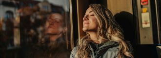 Eine Frau sitzt im Zug und schaut aus dem Fenster.