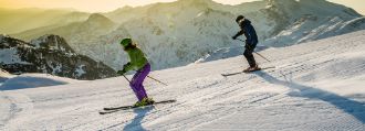 Skifahrer wedeln eine Abfahrt hinunter