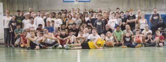 Basketball-Star Dirk Nowitzki steht gemeinsam auf einem Gruppenfoto mit zahlreichen Kindern und Jugendlichen des Projekts BasKIDball. 