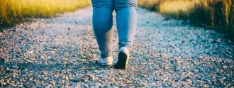 Eine Frau mit korpulenten Beinen läuft einen Weg entlang