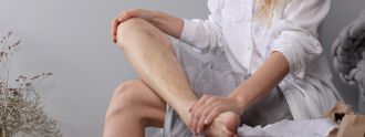 Eine Frau hält sich ihr Bein, auf dem Krampfadern zu sehen sind.