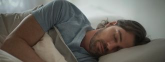 Ein Mann liegt im Bett und schläft.