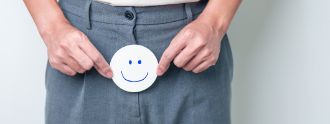 Man sieht einen Mann der einen Smiley vor seinen Intimbereich hält.
