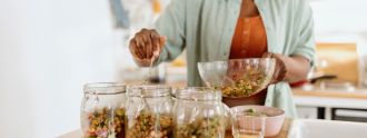 Eine Frau portioniert Salat in verschiedenen Gläser.