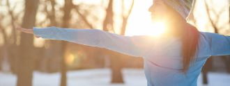 Frau macht Yoga draussen im Winter