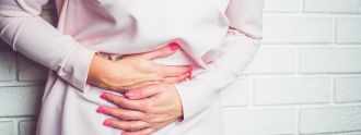 Frau mit Endometriose hält sich schmerzenden Bauch