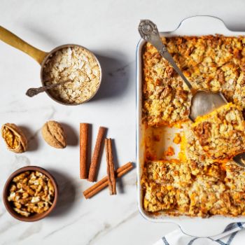 Karrotenkuchen in einer Auflaufform mit den Zutaten daneben.
