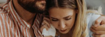 Ein Mann umarmt seine traurige Frau.