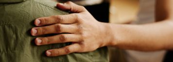 Eine Person legt ihre Hand auf die Schulter einer anderen Person.