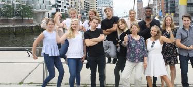 Eine Gruppe Auszubildender posiert in der Hamburger Hafencity in die Kamera.