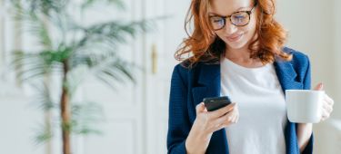 Personen sitzen auf dem Sofa und checken ihre Nachrichten digital