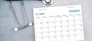 Auf einem Tisch liegt ein Stethoskop und ein Kalender.